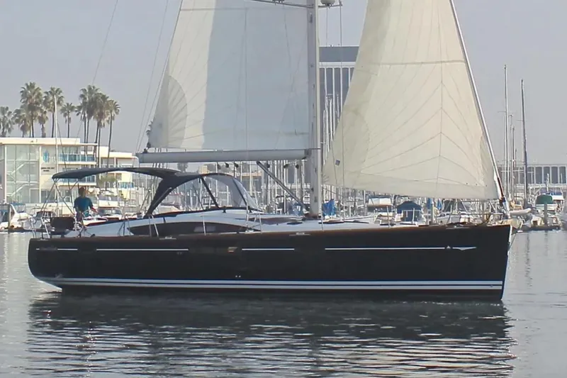 Slide: The Image of 2011 Jeanneau 57 sailboat cruising in a marina with sails up. - 0