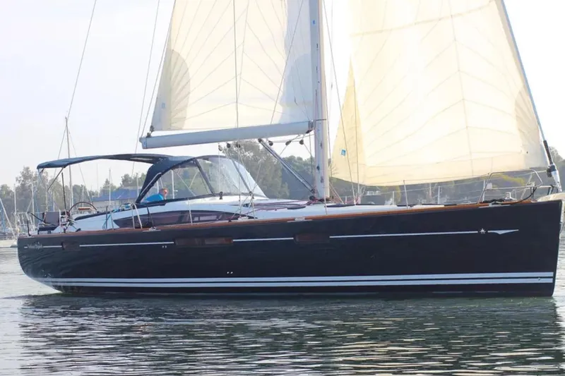 Slide: The Image of 2011 Jeanneau 57 sailboat with white sails on calm water. - 1