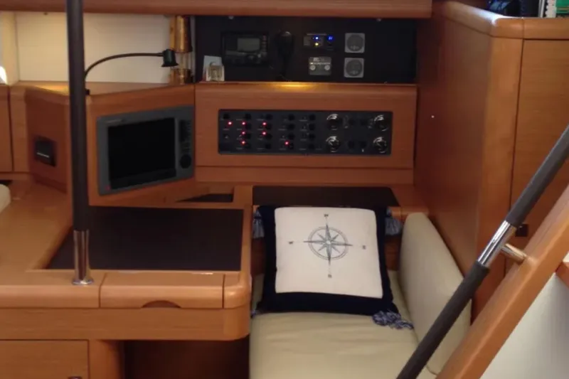 Slide: The Image of Interior of 2011 Jeanneau 57 yacht with navigation equipment and compass-themed cushion. - 27