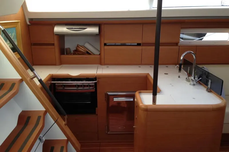 Slide: The Image of Interior of 2011 Jeanneau 57 yacht kitchen with wooden cabinetry and modern appliances. - 31
