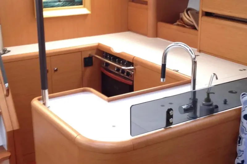 Slide: The Image of Interior of 2011 Jeanneau 57 yacht kitchen with modern fixtures and wood cabinetry. - 32
