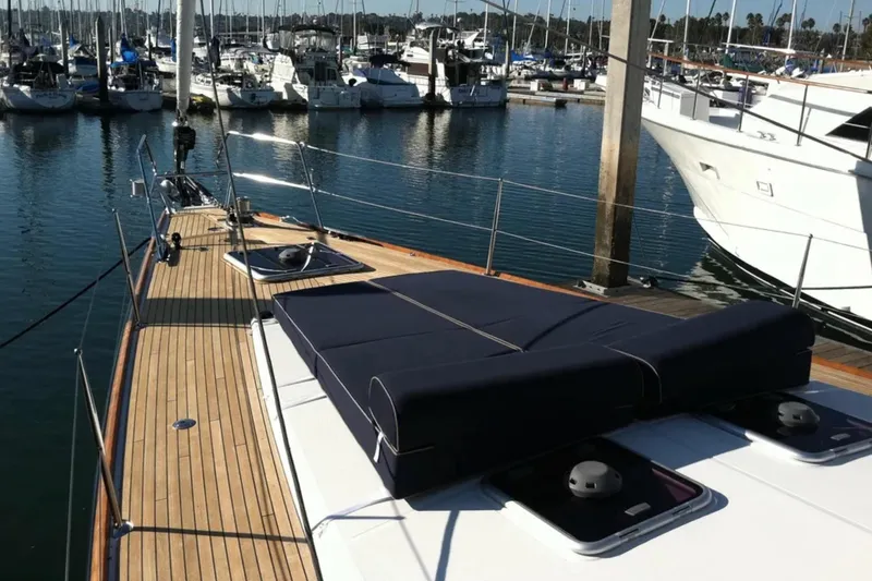 Slide: The Image of 2011 Jeanneau 57 yacht docked in marina, showcasing sleek deck design. - 9
