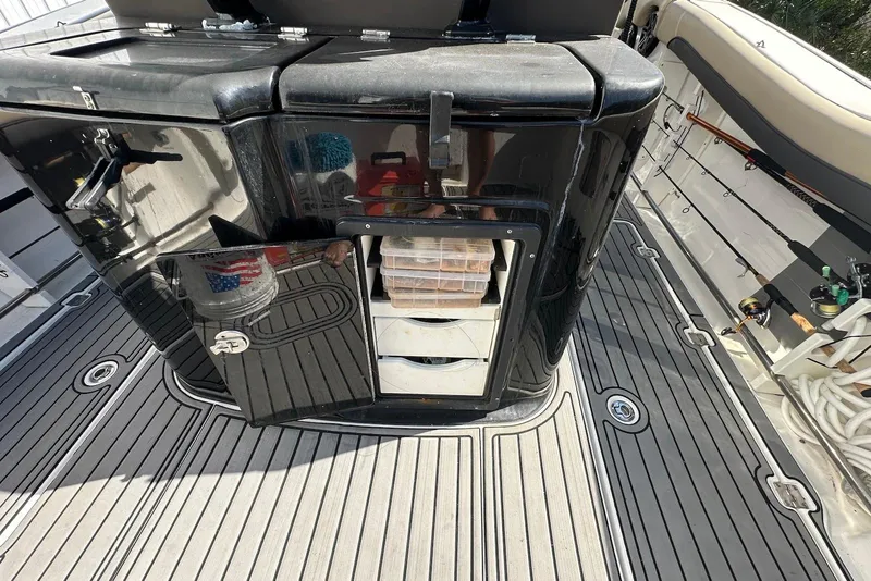 Slide: The Image of 2018 Tidewater 320 CC Adventure boat deck with storage compartment open. - 17