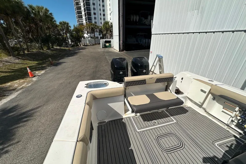 Slide: The Image of 2018 Tidewater 320 CC Adventure boat with dual engines, docked near a building. - 20