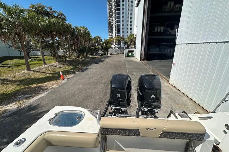 Slide: The Image of 2018 Tidewater 320 CC Adventure boat with dual outboard engines near storage facility. - 22