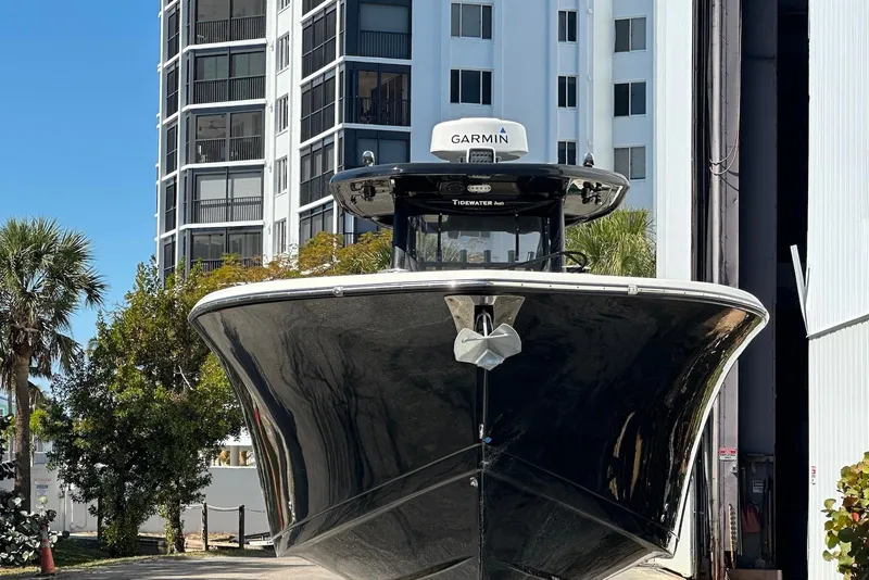 Slide: The Image of 2018 Tidewater 320 CC Adventure boat docked near modern buildings. - 3