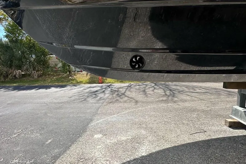 Slide: The Image of 2018 Tidewater 320 CC Adventure boat hull, parked outdoors on a sunny day. - 4