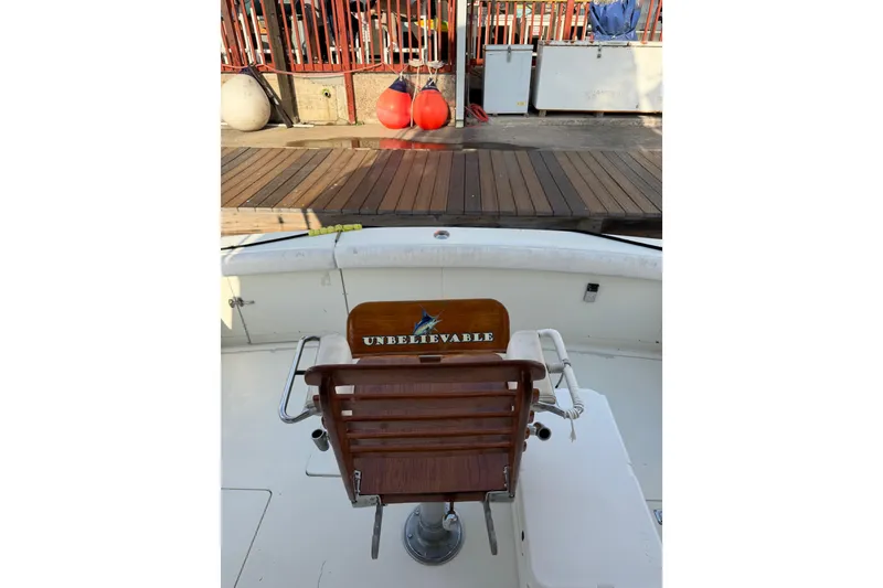 Slide: The Image of 1984 Bertram 42 Convertible boat with "Unbelievable" chair at dockside. - 12
