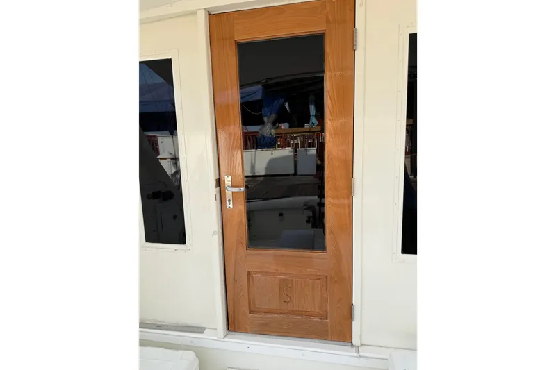 Slide: The Image of 1984 Bertram 42 Convertible yacht wooden door with glass panel. - 13
