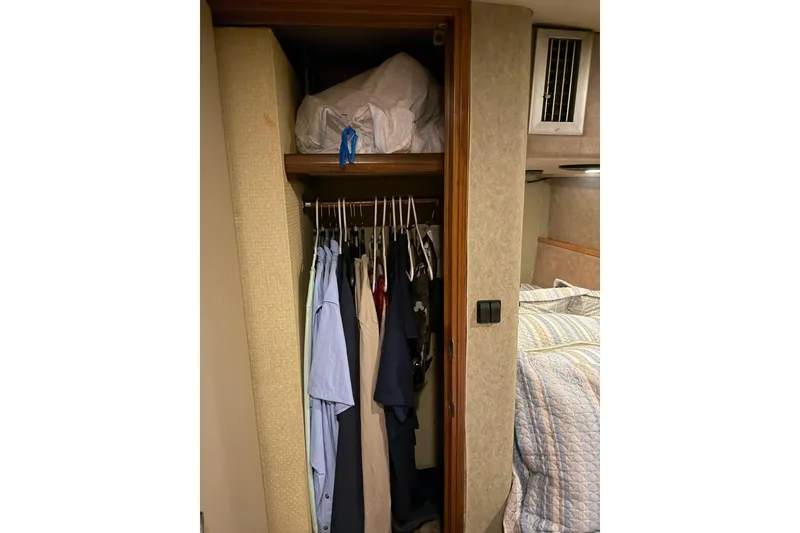 Slide: The Image of Closet with clothes in 1984 Bertram 42 Convertible boat interior. - 21