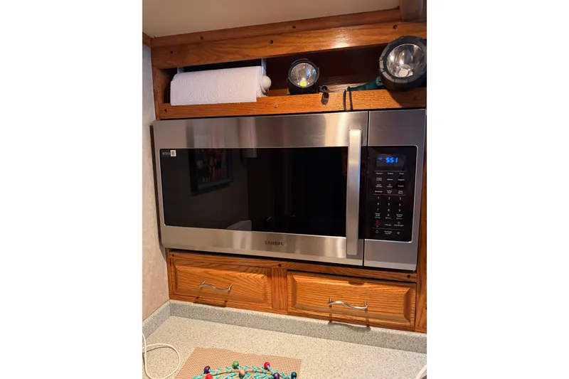 Slide: The Image of Microwave in 1984 Bertram 42 Convertible kitchen with wooden cabinetry and countertop. - 28