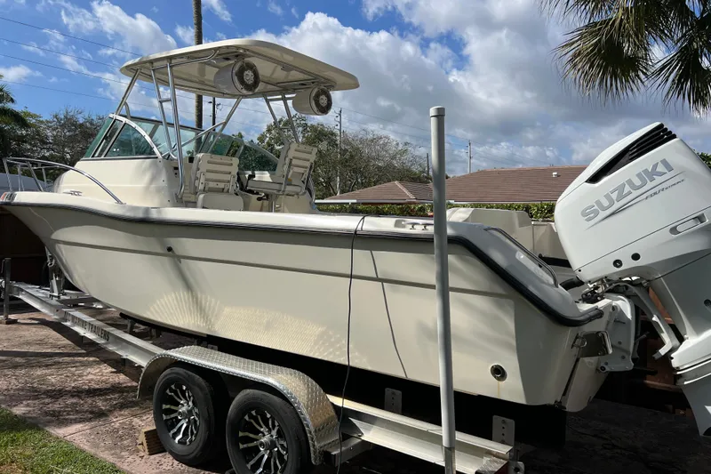 Slide: The Image of 1999 Pursuit 2470 Walkaround boat on trailer with Suzuki outboard motor. - 10