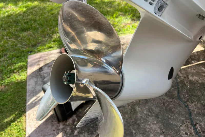 Slide: The Image of Close-up of a 1999 Pursuit 2470 Walkaround boat propeller on grass. - 12