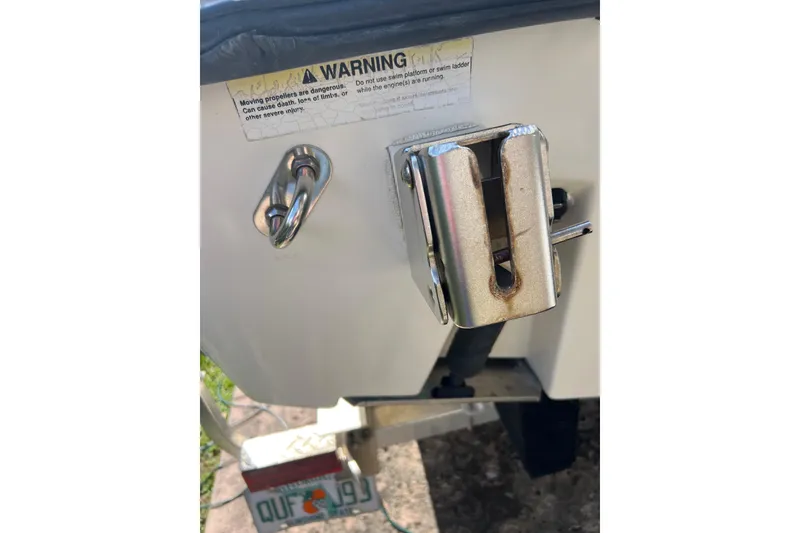 Slide: The Image of 1999 Pursuit 2470 Walkaround boat stern with warning label and metal fittings. - 29