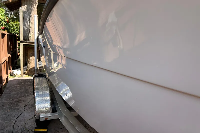 Slide: The Image of 1999 Pursuit 2470 Walkaround boat on trailer, side view, outdoors. - 5