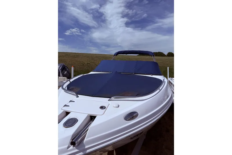 Slide: The Image of 2008 Chaparral 246 SSi boat with blue cover under a partly cloudy sky. - 14