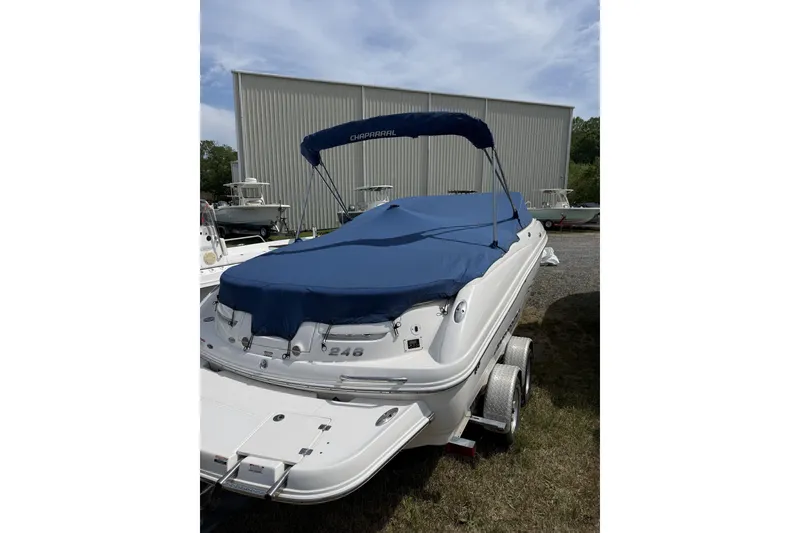 Slide: The Image of 2008 Chaparral 246 SSi boat with blue cover and trailer, parked outdoors. - 15
