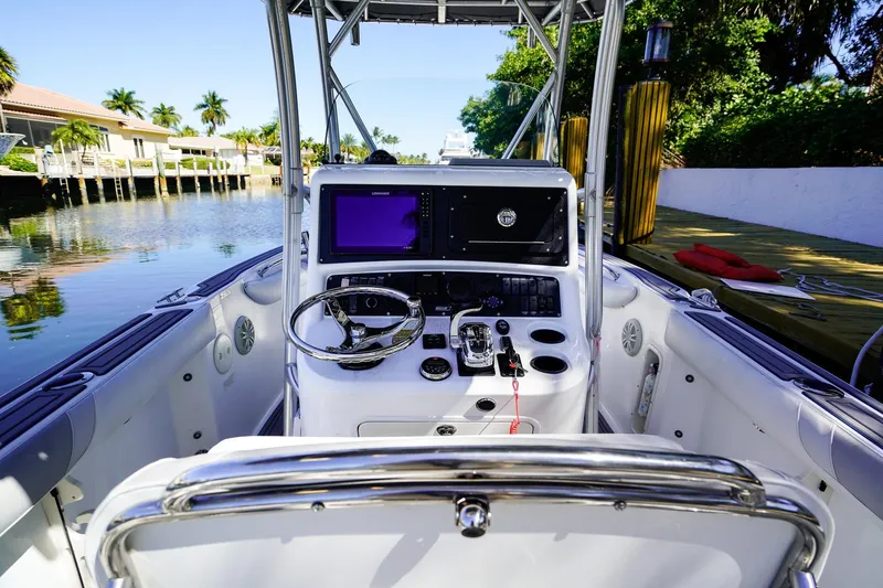 Slide: The Image of 2004 Boston Whaler 240 Outrage boat cockpit with steering wheel and control panel. - 12