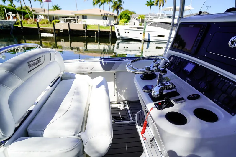 Slide: The Image of 2004 Boston Whaler 240 Outrage boat interior with steering wheel and control panel. - 14