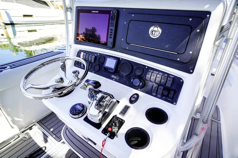 Slide: The Image of Boston Whaler 240 Outrage 2004 boat console with steering wheel and navigation controls. - 16