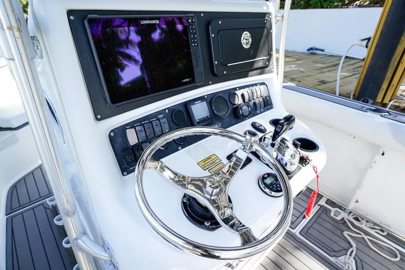 Slide: The Image of Control panel of a 2004 Boston Whaler 240 Outrage boat with steering wheel and navigation equipment. - 17