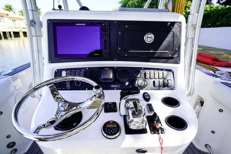 Slide: The Image of Control panel of a 2004 Boston Whaler 240 Outrage boat with steering wheel and navigation equipment. - 18