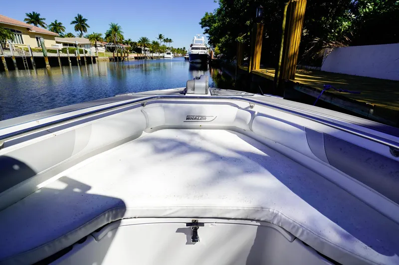 Slide: The Image of 2004 Boston Whaler 240 Outrage boat on a sunny canal with palm trees. - 23