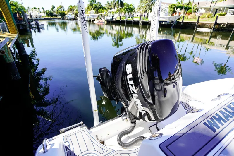 Slide: The Image of 2004 Boston Whaler 240 Outrage with Suzuki outboard motor on a calm waterway. - 4