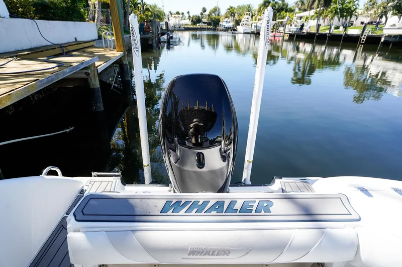 Slide: The Image of 2004 Boston Whaler 240 Outrage boat docked by a calm waterfront. - 5