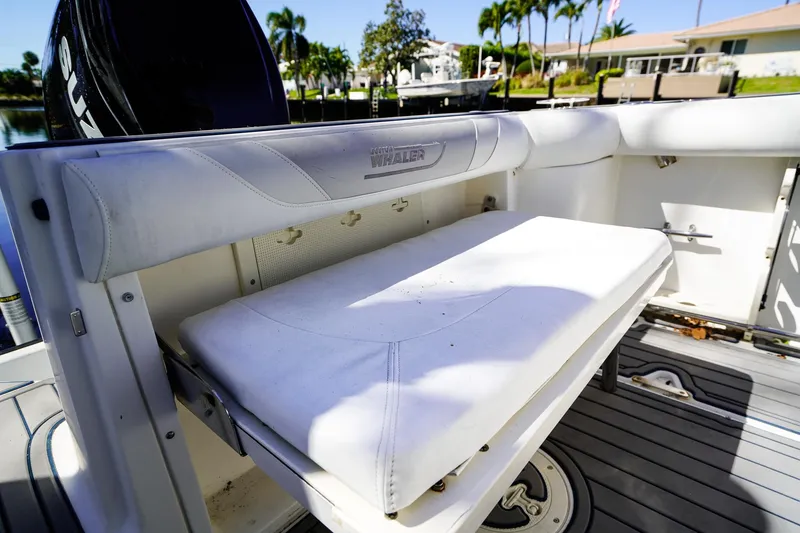 Slide: The Image of 2004 Boston Whaler 240 Outrage boat seat, white upholstery, docked near waterfront homes. - 8