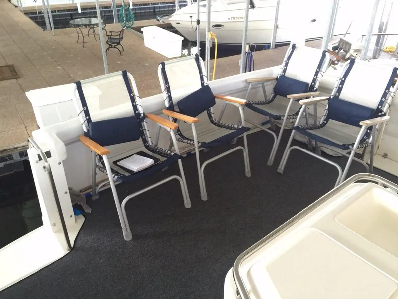 Slide: The Image of 1998 Silverton 372 Motor Yacht deck area with blue chairs. - 17