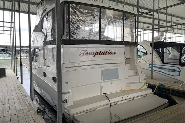 Slide: The Image of 1998 Silverton 372 Motor Yacht docked, named "Temptation," with covered upper deck. - 38