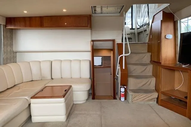 Slide: The Image of 1998 Silverton 372 Motor Yacht interior with beige seating, wooden cabinetry, and staircase. - 39