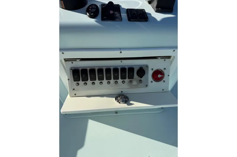 Slide: The Image of Control panel of a 2017 Sabalo 22 boat with switches and dials. - 13