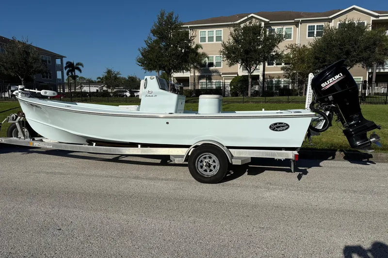 Slide: The Image of 2017 Sabalo 22 boat on trailer with Suzuki outboard motor, parked near residential area. - 5