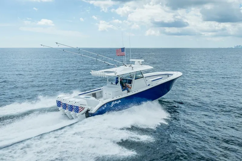 Slide: The Image of 2023 Yellowfin 39 Offshore boat cruising on open ocean with American flag. - 28