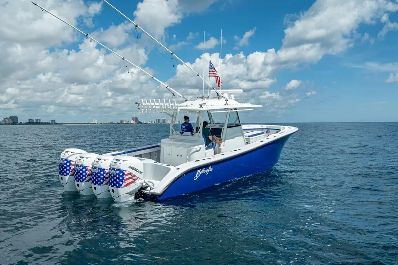 Slide: The Image of 2023 Yellowfin 39 Offshore boat with American flag-themed engines on open water. - 4