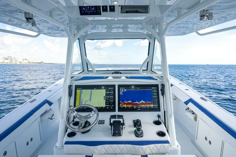 Slide: The Image of 2023 Yellowfin 39 Offshore boat dashboard with navigation screens on open sea. - 47