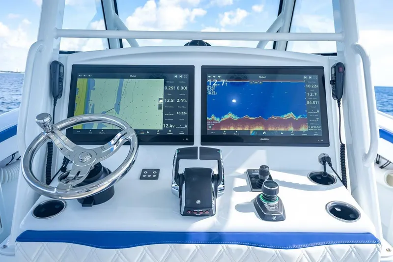 Slide: The Image of 2023 Yellowfin 39 Offshore boat dashboard with dual Garmin displays and steering wheel. - 51