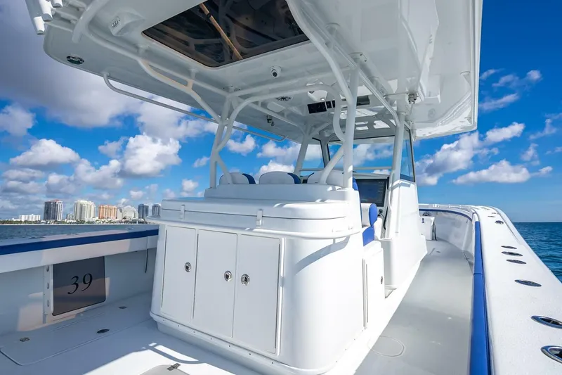 Slide: The Image of 2023 Yellowfin 39 Offshore boat on open water, clear sky, city skyline in background. - 62