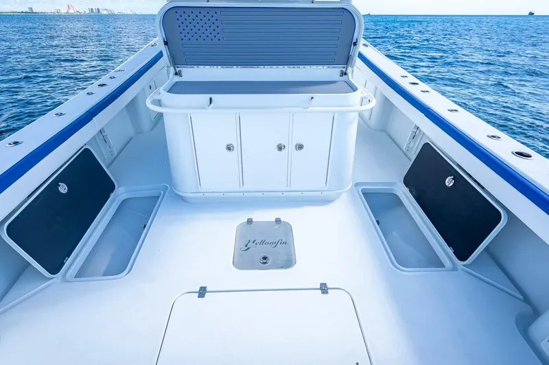 Slide: The Image of 2023 Yellowfin 39 Offshore boat deck with storage compartments, open sea view. - 63