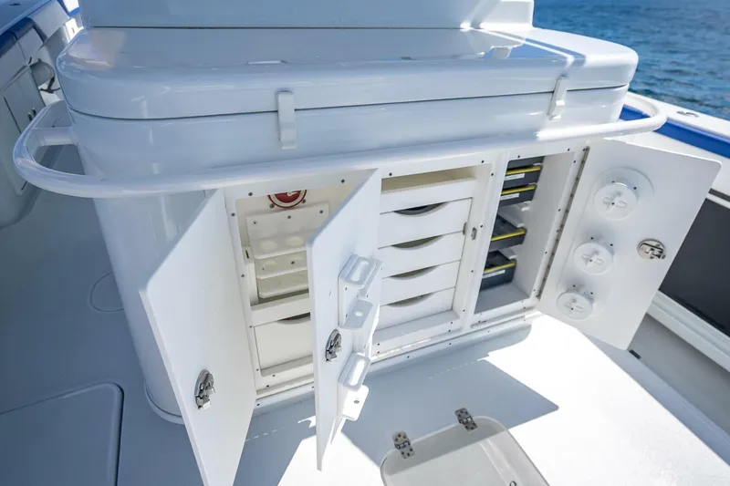 Slide: The Image of 2023 Yellowfin 39 Offshore boat storage compartments with open doors, showcasing organized interior. - 65