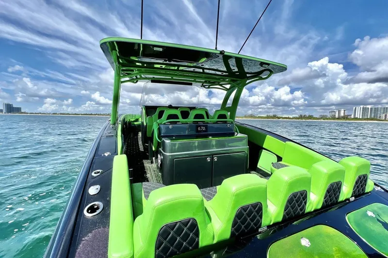 Slide: The Image of 2020 Midnight Express 43 Open boat with vibrant green seating on a sunny day. - 14