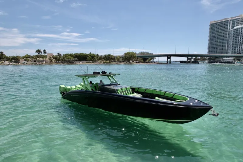 Slide: The Image of 2020 Midnight Express 43 Open boat on clear turquoise water near a bridge. - 19