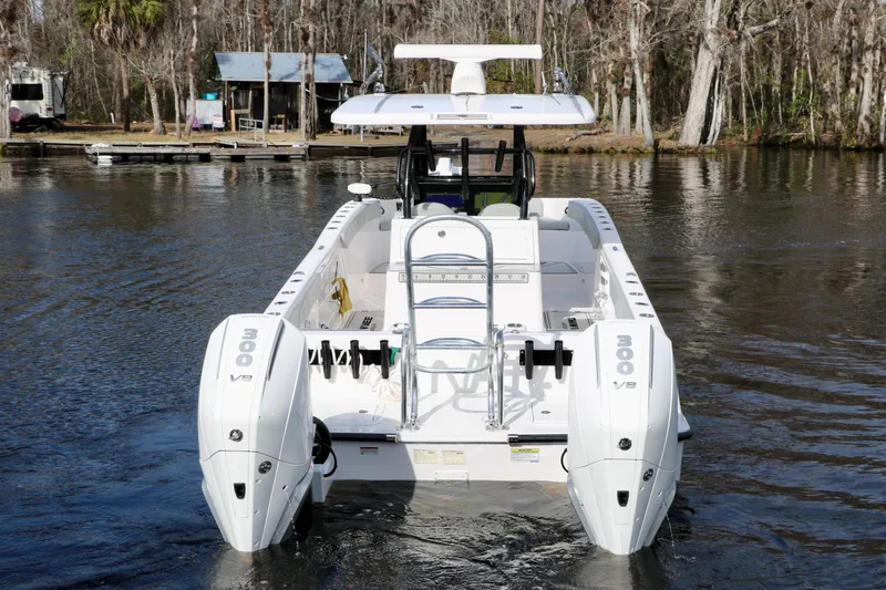 Slide: The Image of 2024 Twin Vee 280 GFX CC boat with dual 300 V8 engines on a calm river. - 1