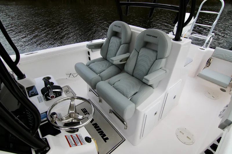 Slide: The Image of 2024 Twin Vee 280 GFX CC boat interior with dual captain's chairs and steering wheel. - 12