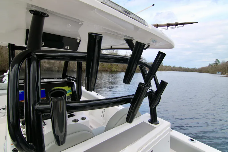 Slide: The Image of 2024 Twin Vee 280 GFX CC boat with rod holders on a serene river. - 13
