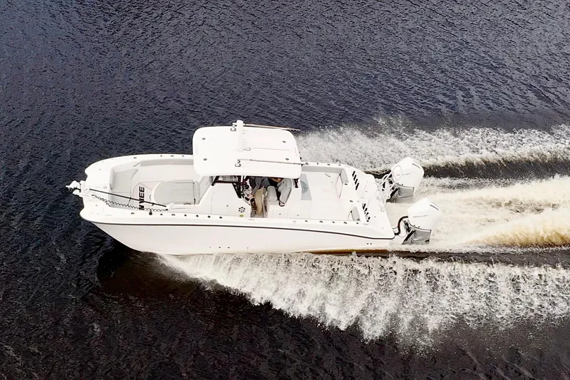 Slide: The Image of 2024 Twin Vee 280 GFX CC boat cruising on water, aerial view. - 6