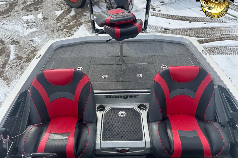 Slide: The Image of 2020 Ranger Z521L boat interior with red and black seats on snowy ground. - 9