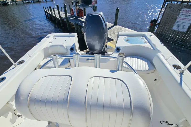Slide: The Image of 2014 Sea Fox 199 Commander boat interior with seating and rod holders at dock. - 12